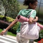 Sac à main cours rose de grande capacité porté par une femme dynamqiue